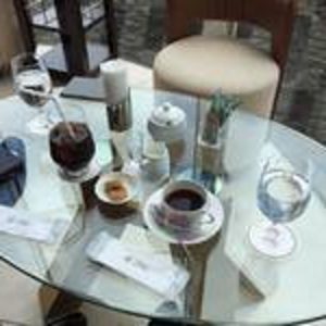 おしゃれなガラステーブルの上にコーヒーが並んでいる写真の画像