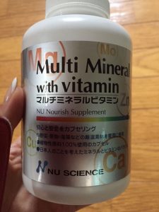 マルチビタミンサプリのボトルを手で持っている写真の画像