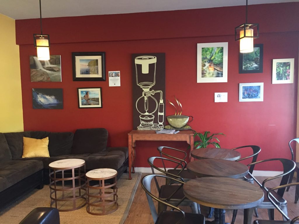 サイフォンの絵が赤い壁に飾られたおしゃれなカフェの写真の画像