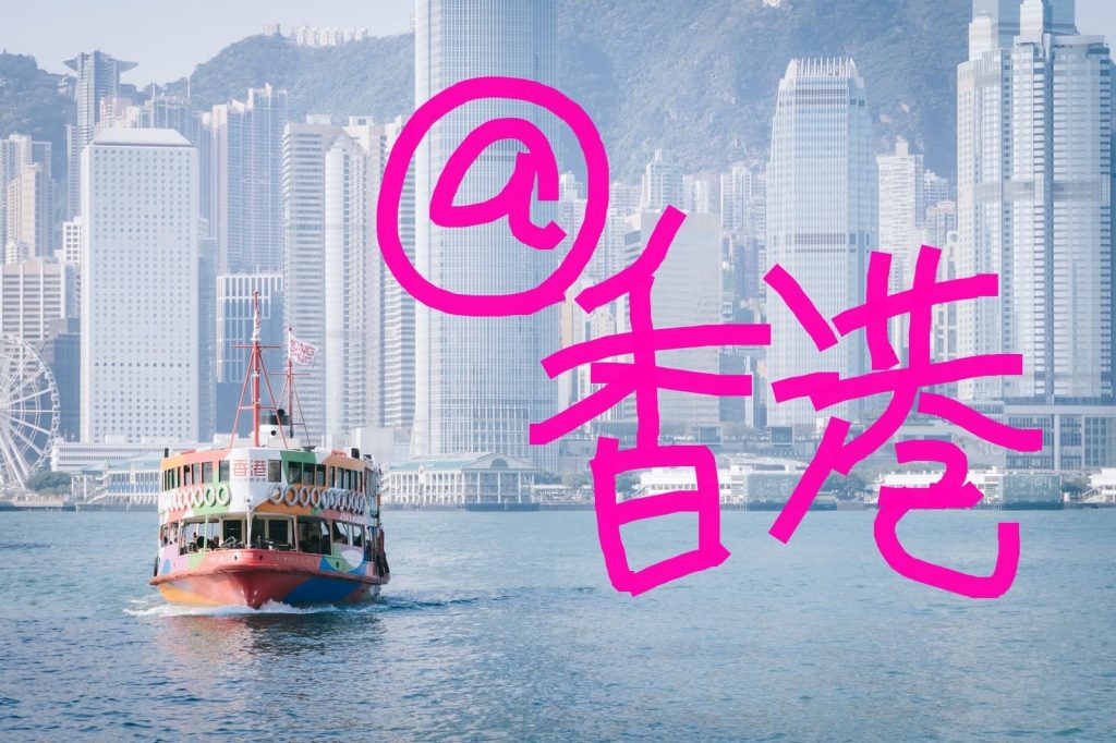 香港の景色を背景に海上を船が進んでいる画像