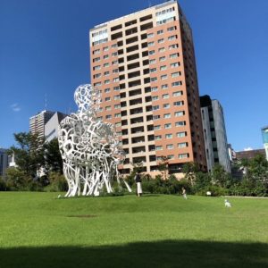 虎ノ門ヒルズと芝生の上の白いモニュメントの写真の画像