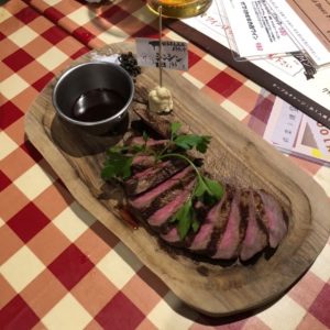 木製のプレートに盛られたステーキの写真の画像