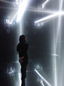 プロジェクションマッピングの中に立っている女性の後ろ姿の写真の画像