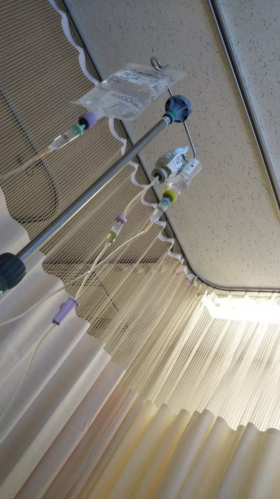 病室の天井と点滴が写った写真の画像