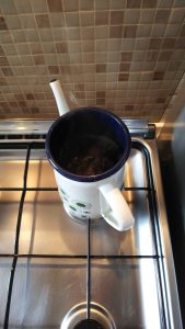 白いポットでお茶を煮出している写真の画像