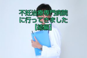 白衣を着た男性が青いファイルを脇に抱えている写真の画像