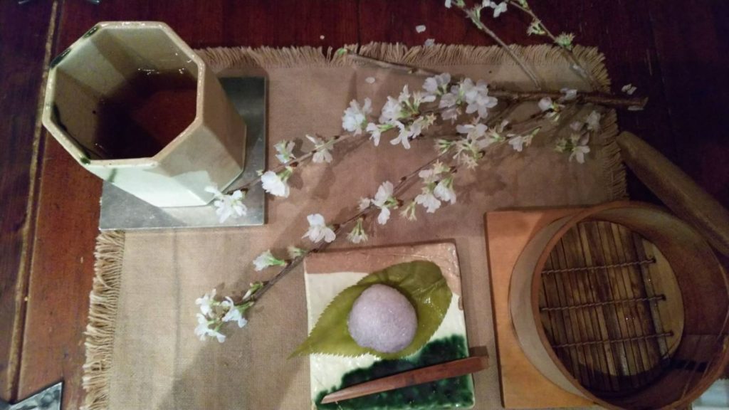 桜餅と桜の枝のテーブルコーディネートの写真の画像